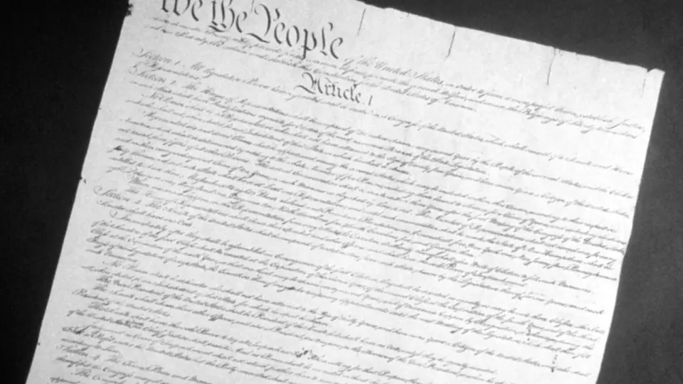 A copy of the United States Constitution displayed beside its protective case.